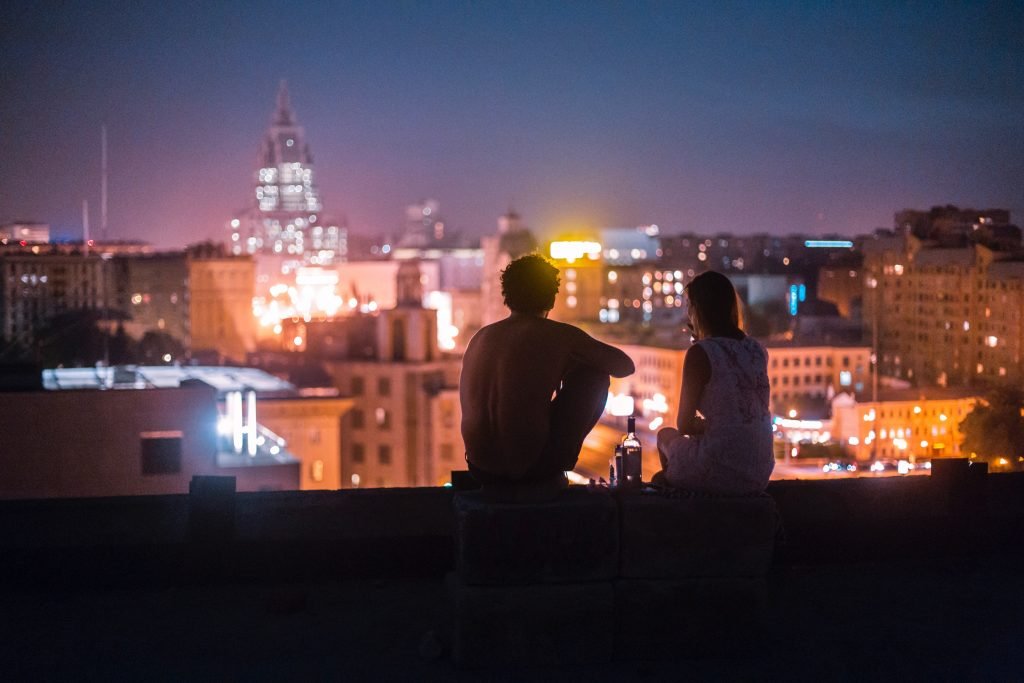man and woman looking at skyline night