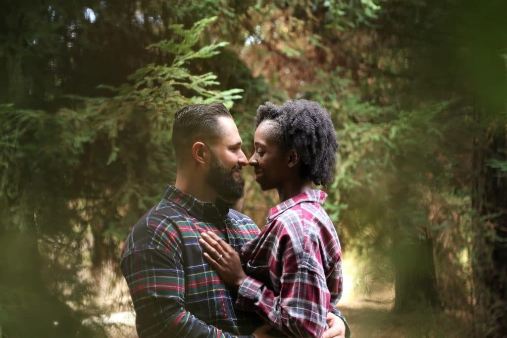 black woman and white man hugging in nature