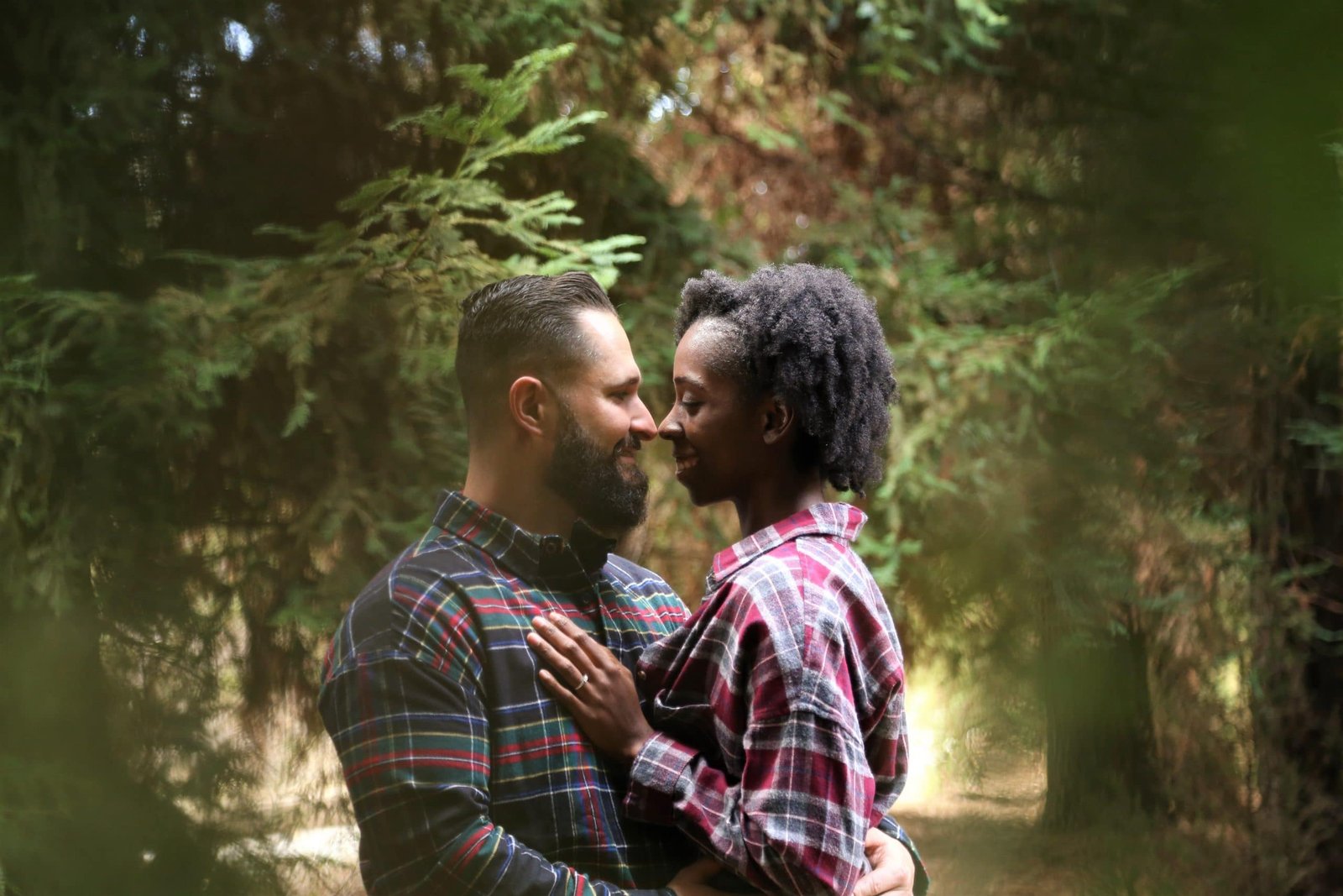 black woman and white man hugging in nature