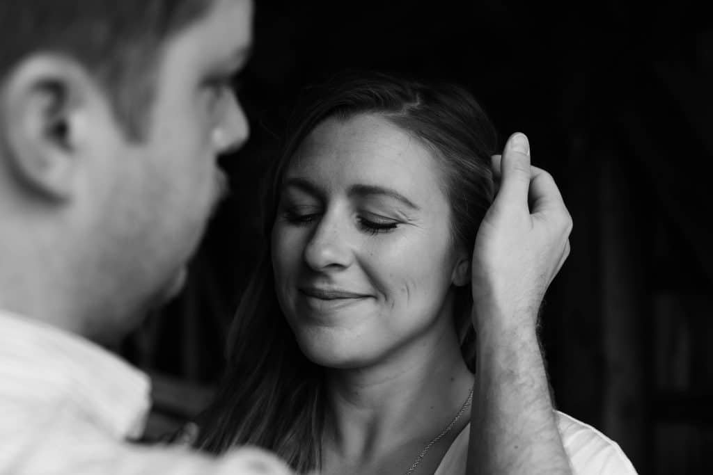 black and white photo man putting hair behind woman's ear